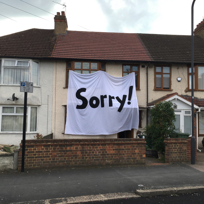 very large banner saying sorry on house in harrow art piece artwork will dalton